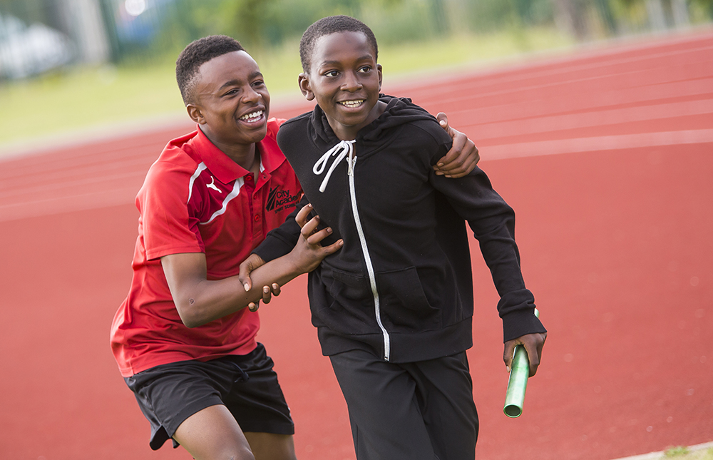 Two young boys running a relay race 