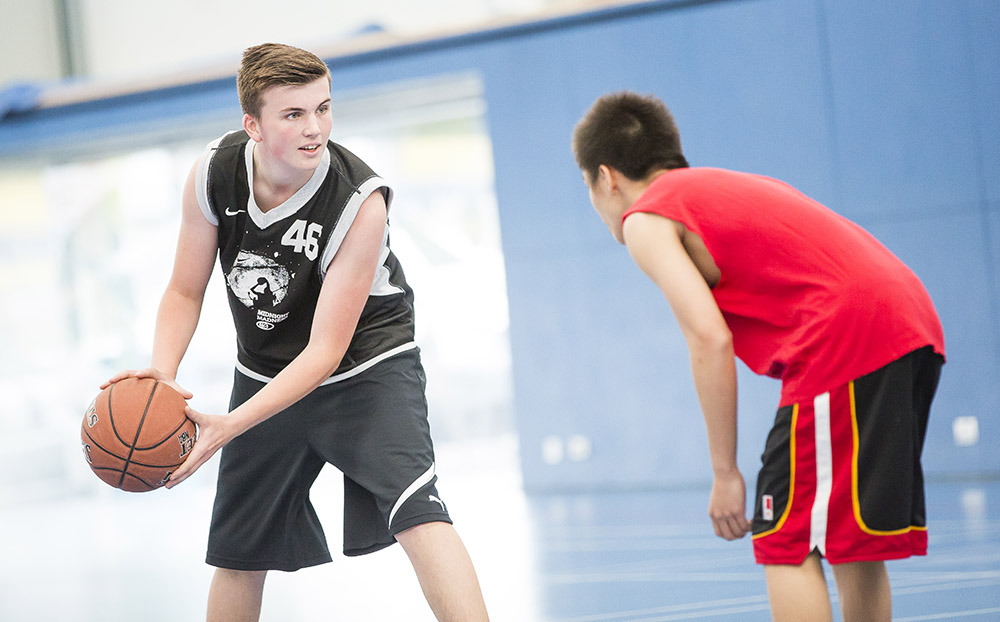 Two young men playing basketball 