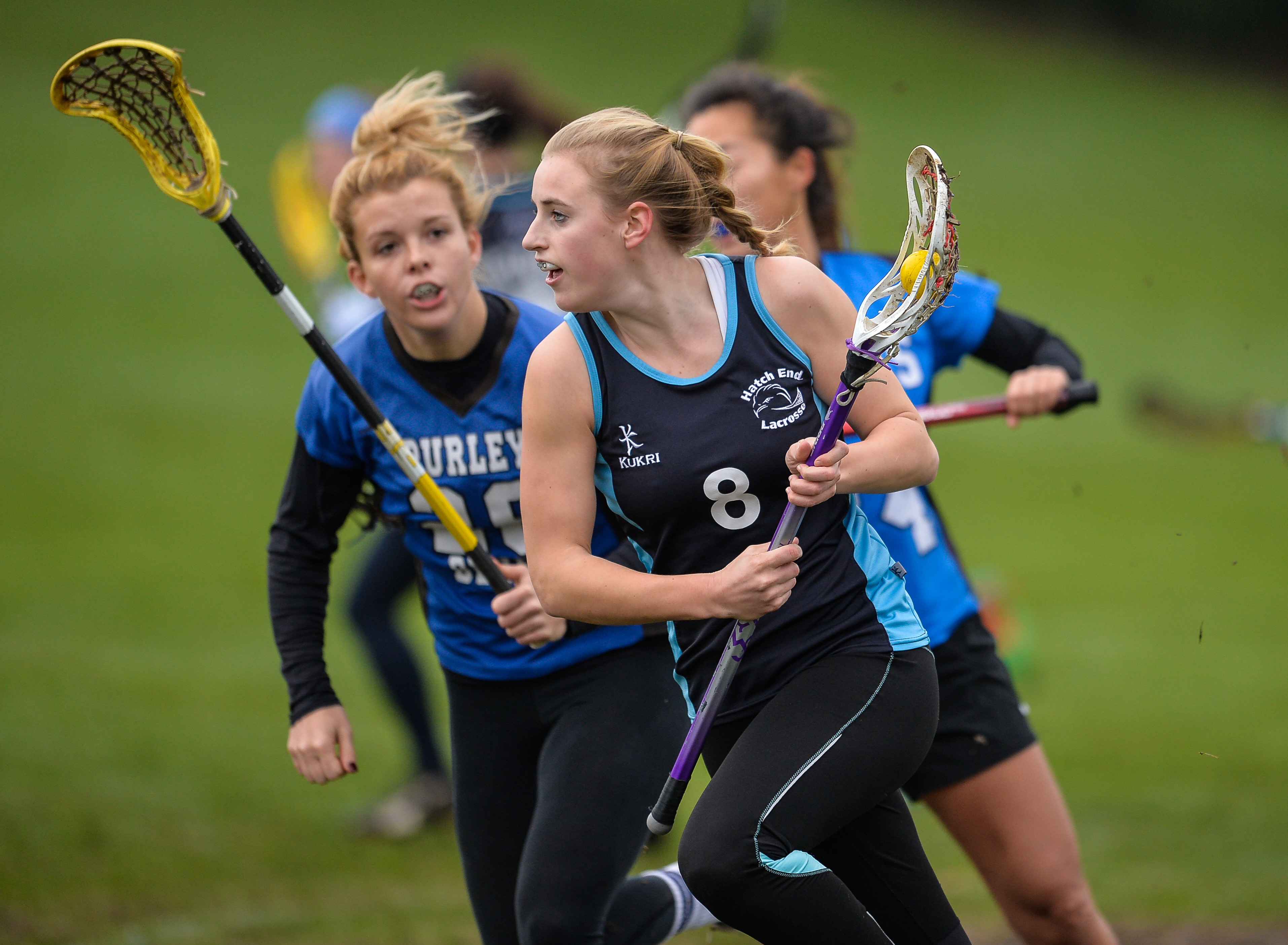 A girl running with a crosse 